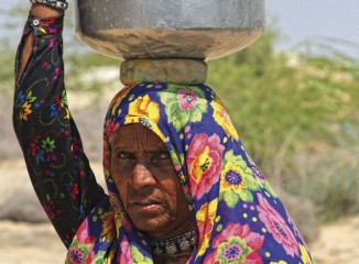 Mujer cargando un recipiente de agua en la cabeza en Bikaner