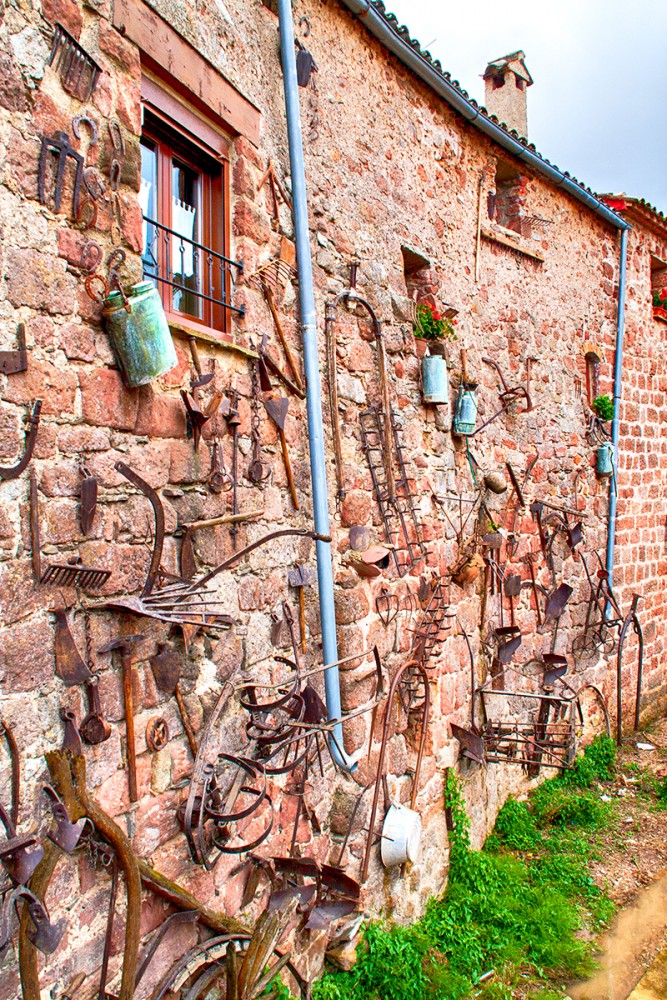 Pared decorada con aperos de hortelano en Prades