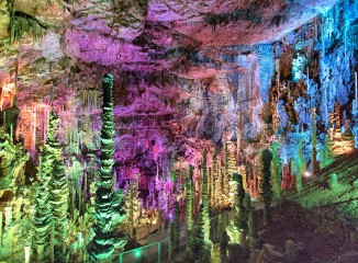 Combinación de luces y colores reflejados sobre las estalagmitas de la cueva