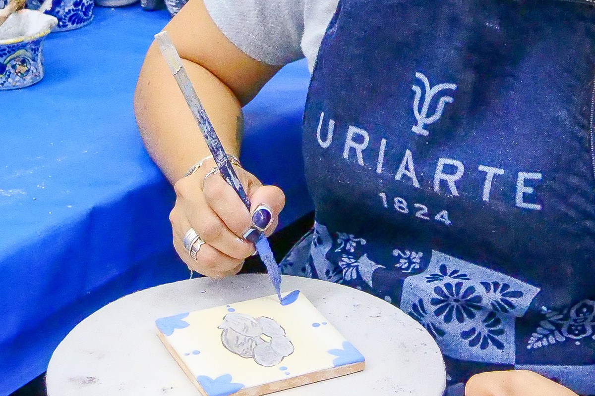 Manos decorando una pieza de Talavera